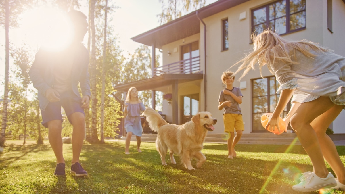 Family playing outdoors with their dog in a clean and comfortable home environment.