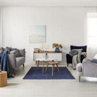 Grey and navy blue living room interior with comfortable sofa and armchairs