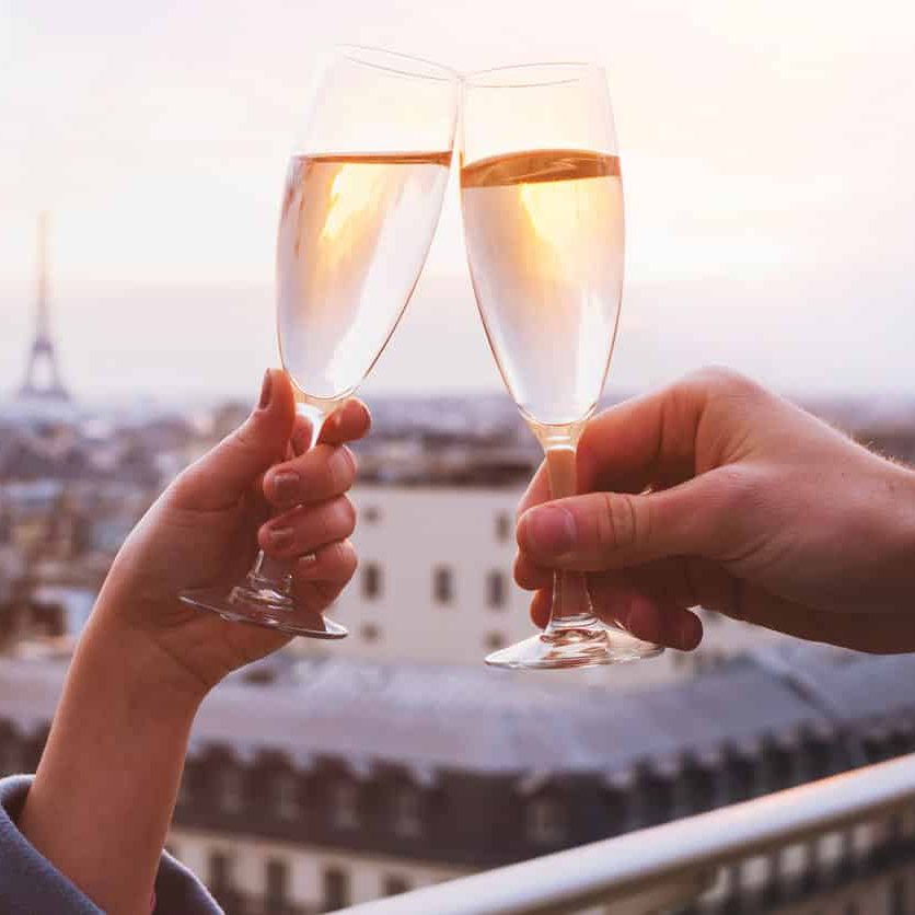 two glasses of champagne or wine, couple in Paris, romantic celebration of engagement or anniversary